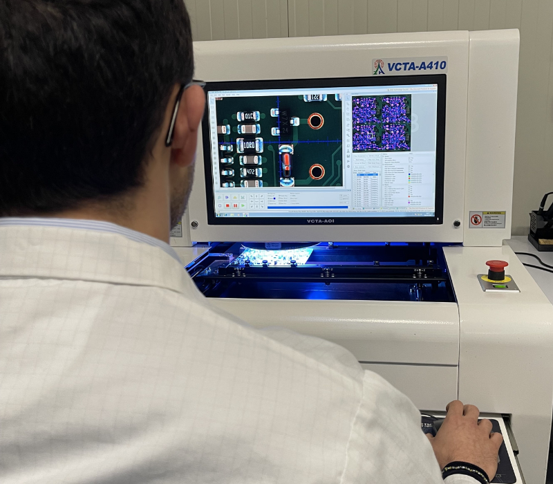 Tecnico qualificato esegue il controllo qualità tramite sistema AOI su schede elettroniche assemblate